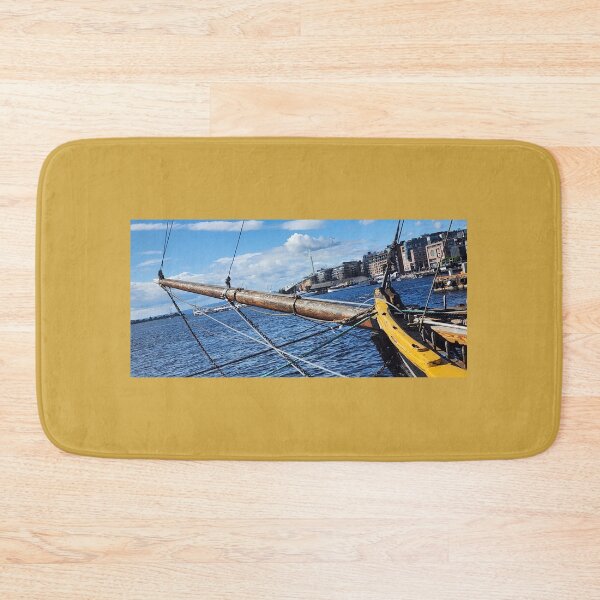 Item preview, Historic ship's wooden bow and bowsprit profiled against a modern Baltic harbor skyline designed and sold by MAMB007.