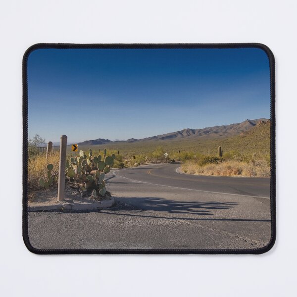 Item preview, A winding desert road curves through a landscape dotted with cacti, set against a backdrop of distant mountains under a clear blue sky designed and sold by EyezWatchin.