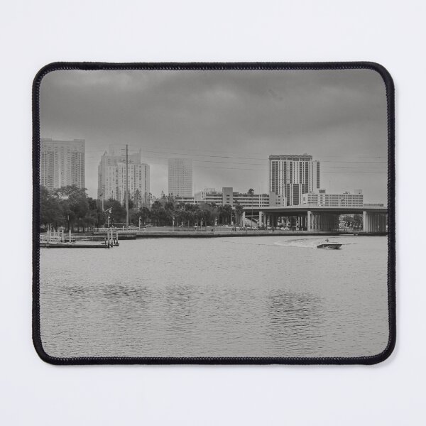 Item preview, A boat glides up the Tampa Bay Riverwalk under a dramatic cloudy sky monochrome designed and sold by EyezWatchin.