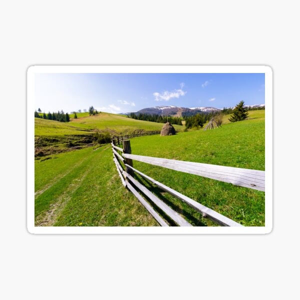 haystack behind the wooden fence on a grassy hill Sticker