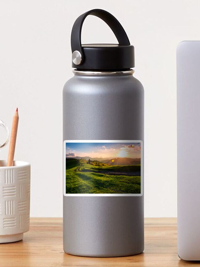 Thumbnail 1 of 3, Sticker, winding road along the grassy rural hill at sunset designed and sold by mike-pellinni.