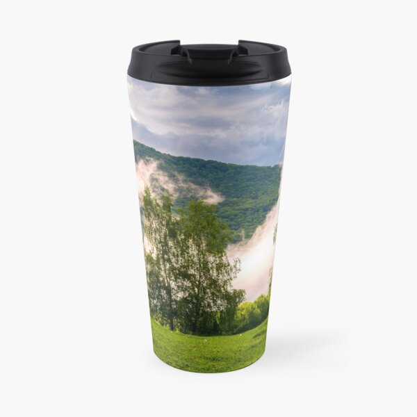 fog rising behind the forest on a hillside Travel Mug