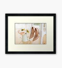 beige shoes for bride hanging on a white chair against a background of a bouquet of pions Framed Print