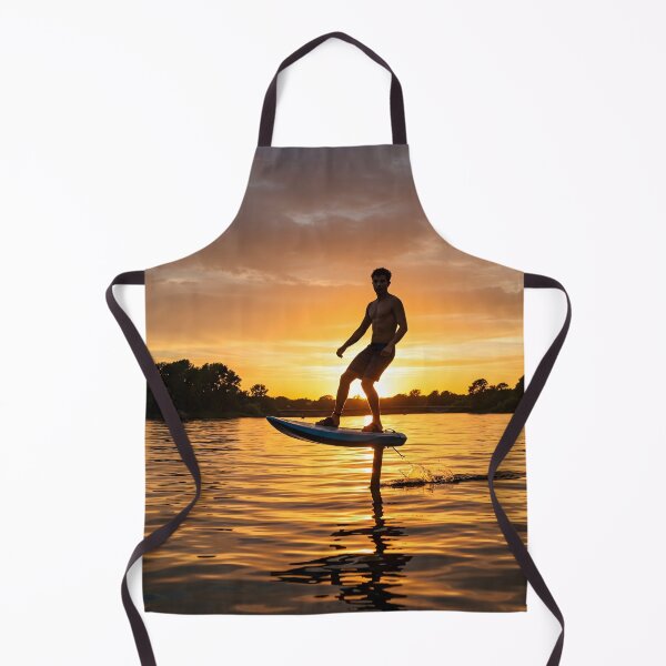 Item preview, Young adult male hydrofoiling on water at sunset, silhouetted against a vibrant orange and cloudy sky designed and sold by homydesign.