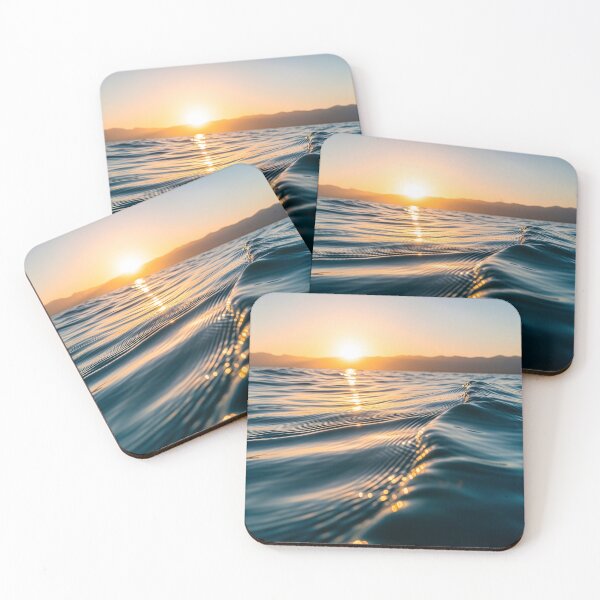 Item preview, Waves shimmer on the water's surface as the sun sets over distant mountains, creating a warm, golden glow designed and sold by homydesign.