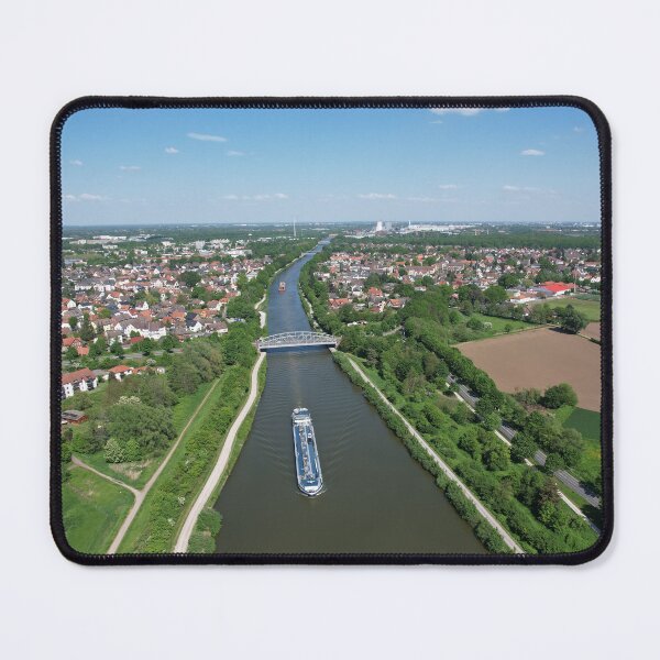 Item preview, cargo ship traveling down on Mittellandkanal river in Seelze Hanover Germany 5K drone view Hanover Germany. Observing a boat moving along the river from above, surrounded by lush greenery, urban buildings, and a vast horizon designed and sold by TravelLensPro.