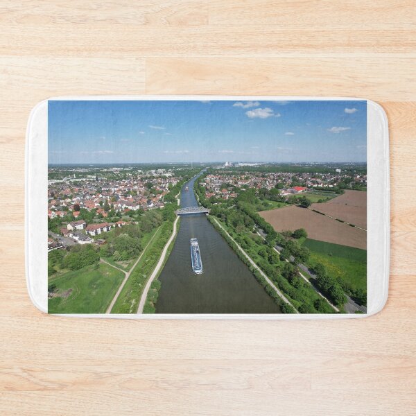 Item preview, cargo ship traveling down on Mittellandkanal river in Seelze Hanover Germany 5K drone view Hanover Germany. Observing a boat moving along the river from above, surrounded by lush greenery, urban buildings, and a vast horizon  designed and sold by TravelLensPro.