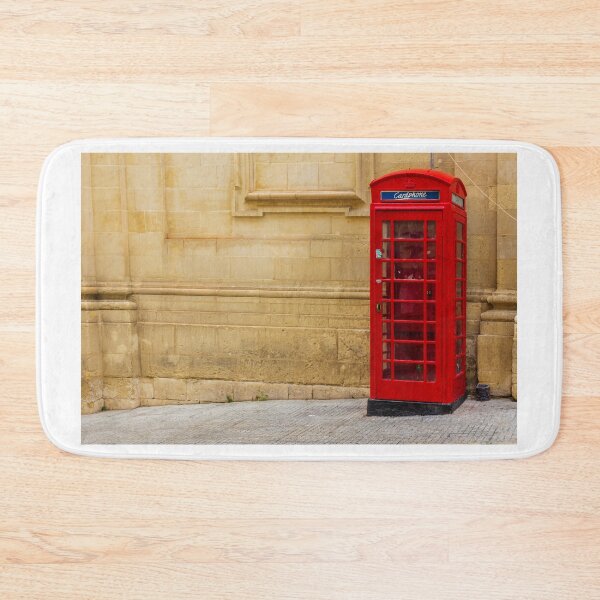 Item preview, Classic Red Telephone Booth Against Historic Stone Wall designed and sold by Nmallia.