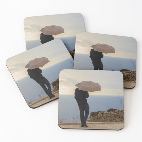Item preview, An unrecognizable person with an Umbrella Standing by Ocean on an Overcast Day designed and sold by Nmallia.