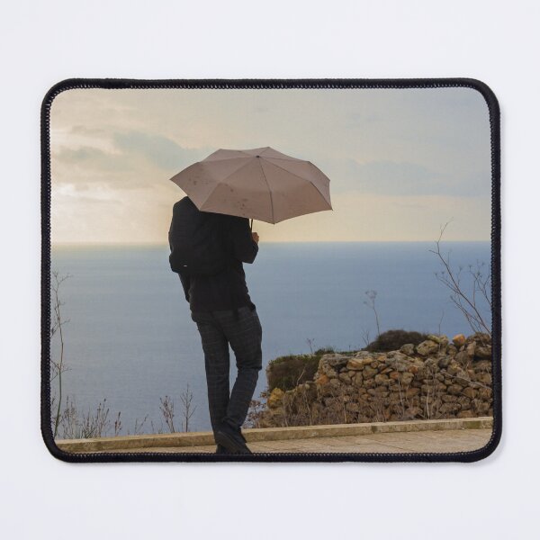 Item preview, An unrecognizable person with an Umbrella Standing by Ocean on an Overcast Day designed and sold by Nmallia.
