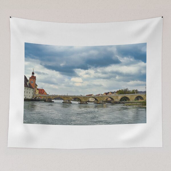 Item preview, Ancient stone bridge over the Danube river and clock tower in Regensburg, Bavaria, Germany designed and sold by goceris.