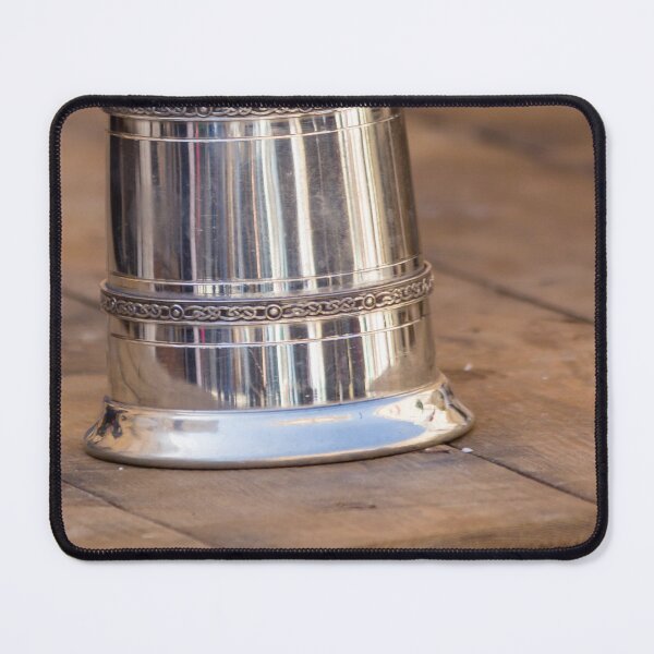 Item preview, Shiny Silver medieval mug With Decorative Band Resting On Rustic Wooden Table Scene designed and sold by Nmallia.