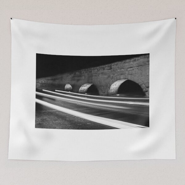 Item preview, Nighttime Stone Bridge With Arches And Light Trails Over A Quiet Urban Road designed and sold by Nmallia.