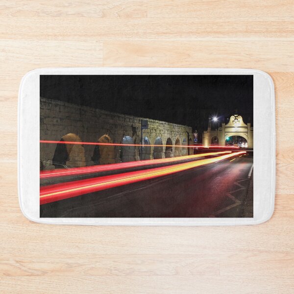 Item preview, Night Street With Historic Stone Archway And Red Light Trails On Busy Urban Road designed and sold by Nmallia.