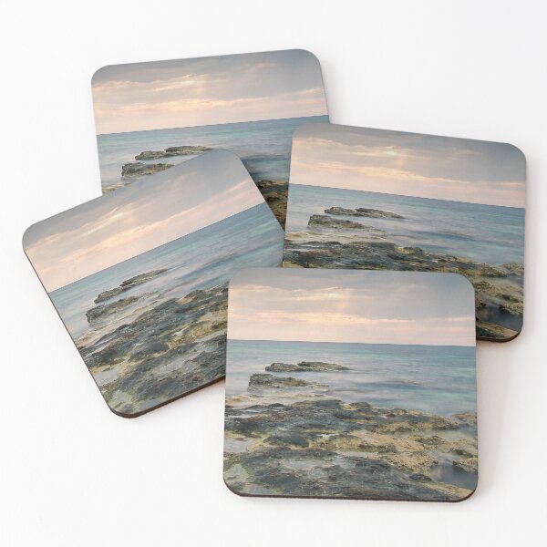 Item preview, Rocky Seashore Path Extends Into Calm Turquoise Ocean Under Soft Sunset Light At Distant Horizon designed and sold by Nmallia.