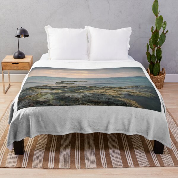 Item preview, Rocky Seashore Path Extends Into Calm Turquoise Ocean Under Soft Sunset Light At Distant Horizon designed and sold by Nmallia.