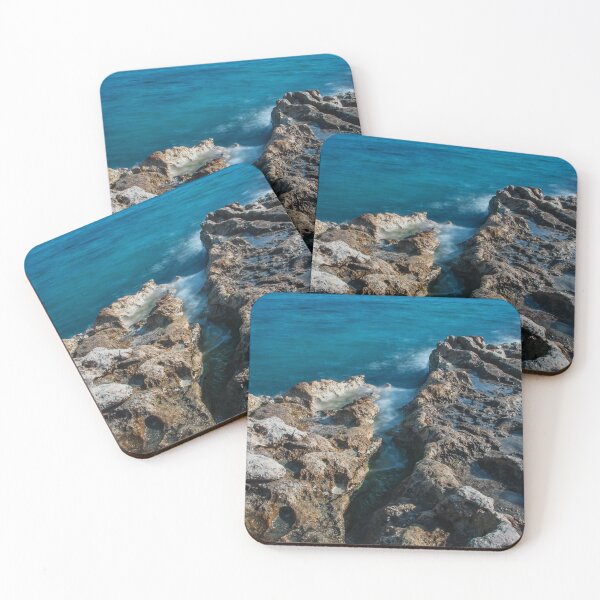 Item preview, Sunlit Turquoise Ocean Crashing Against Rugged Coastal Rocks in a Serene Seascape designed and sold by Nmallia.