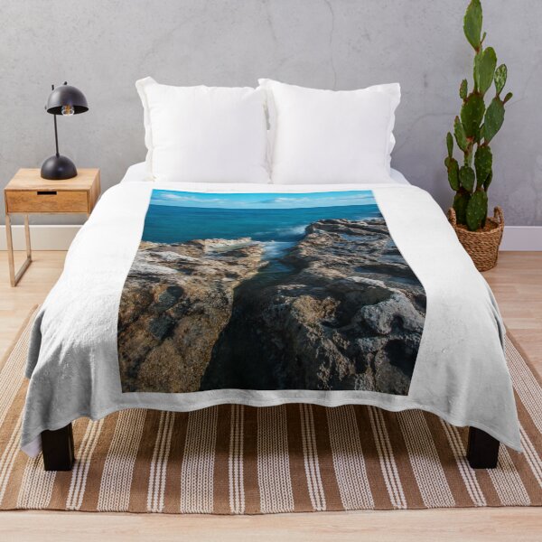 Item preview, Sunlit Turquoise Ocean Crashing Against Rugged Coastal Rocks in a Serene Seascape designed and sold by Nmallia.