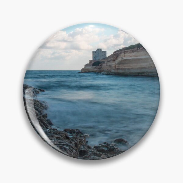 Item preview, Coastal Rocky Shoreline With Turquoise Water, Cliff, And Distant Tower Over Calm Sea designed and sold by Nmallia.