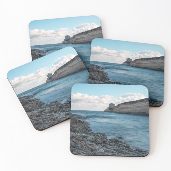 Item preview, Coastal Rocky Shoreline With Turquoise Water, Cliff, And Distant Tower Over Calm Sea designed and sold by Nmallia.