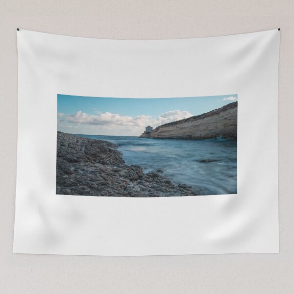 Item preview, Coastal Rocky Shoreline With Turquoise Water, Cliff, And Distant Tower Over Calm Sea designed and sold by Nmallia.