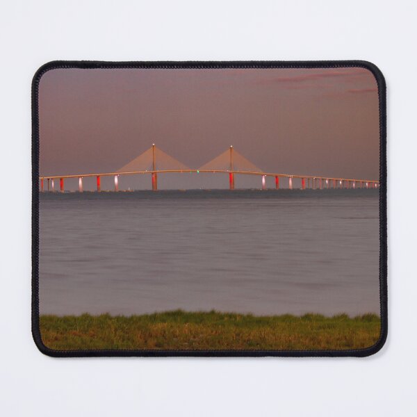 Item preview, The Sunshine Skyway Bridge stretches gracefully across Tampa Bay at dawn, bathed in soft golden light as the new day begins designed and sold by EyezWatchin.