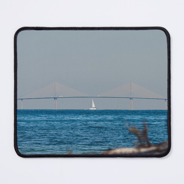 Item preview, A sailboat glides symmetrically beneath the Sunshine Skyway Bridge in Tampa Bay, Florida, creating a striking sense of balance and scale. designed and sold by EyezWatchin.