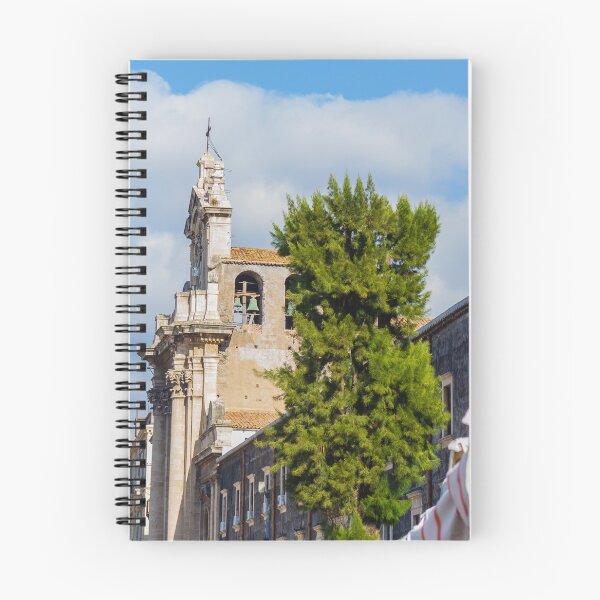 Item preview, Historic Stone Church Tower With Bells Overlooking Quiet Town Street and Green Tree Under Blue Sky designed and sold by Nmallia.