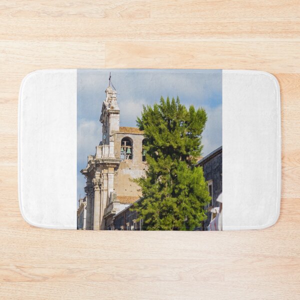 Item preview, Historic Stone Church Tower With Bells Overlooking Quiet Town Street and Green Tree Under Blue Sky designed and sold by Nmallia.