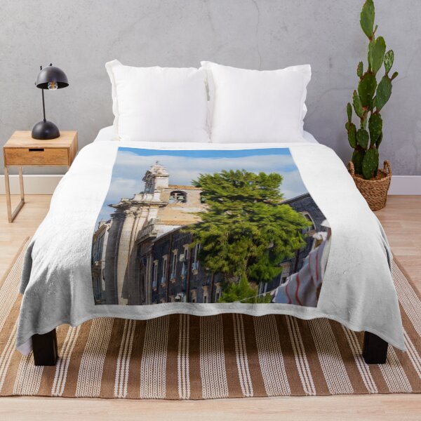 Item preview, Historic Stone Church Tower With Bells Overlooking Quiet Town Street and Green Tree Under Blue Sky designed and sold by Nmallia.