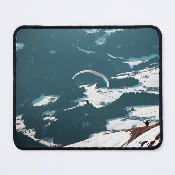 Item preview, Paraglider flying over dramatic alpine valley while hiker ascends snowy mountain slope with panoramic winter landscape designed and sold by VasilisLens.