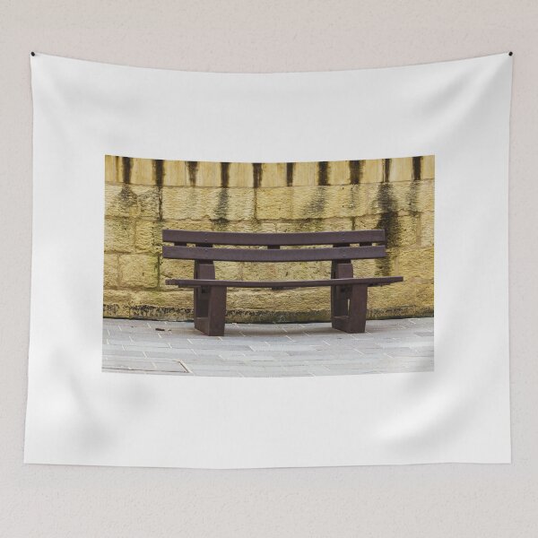 Item preview, Dark Brown Wooden Bench Against Weathered Yellow Stone Wall in Urban Plaza Morning Light designed and sold by Nmallia.