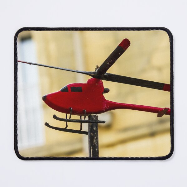 Item preview, Red Model Helicopter Weather Vane On Post With Blurred Urban Background In Sunlit City designed and sold by Nmallia.