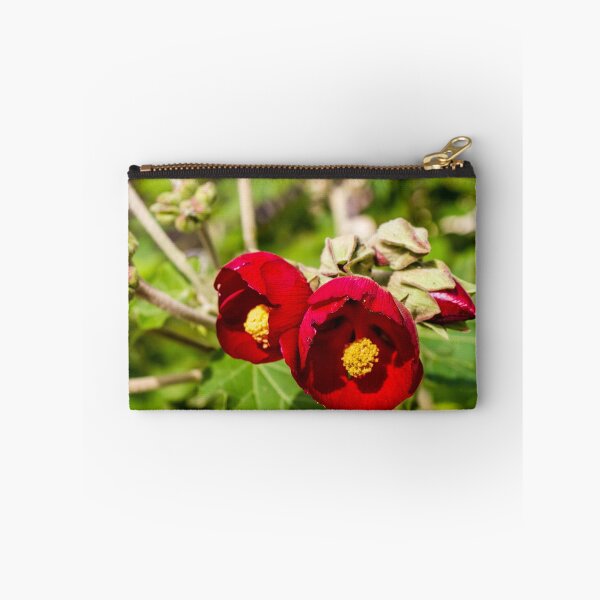 Artikelvorschau, Leuchtend rote Hibiskusblüten mit gelben Zentren im grünen Gartenbeet entworfen und verkauft von Nmallia.