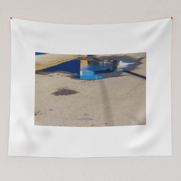 Item preview, Puddle On Wet Road Surface Reflects Buildings In Bright Urban Street Scene designed and sold by Nmallia.