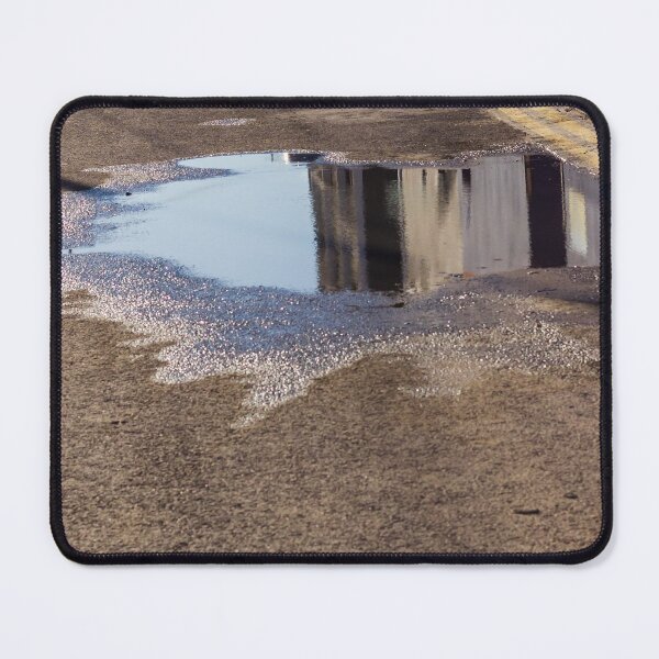 Item preview, Puddle On Wet Road Surface Reflects Buildings In Bright Urban Street Scene designed and sold by Nmallia.