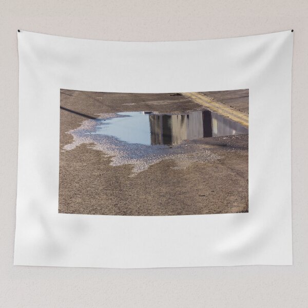 Item preview, Puddle On Wet Road Surface Reflects Buildings In Bright Urban Street Scene designed and sold by Nmallia.