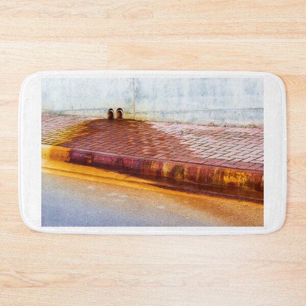 Item preview, Urban Street Curb With Bricked Sidewalk and Sewer Vent Pipes Against Weathered Concrete Wall designed and sold by Nmallia.
