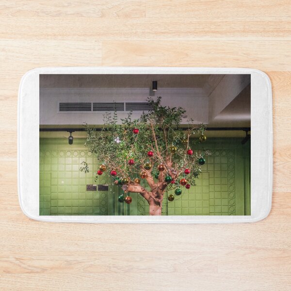 Item preview, Festive Indoor Christmas Tree Decorated With Ornaments Against Modern Green Wall in Bright Lobby designed and sold by Nmallia.