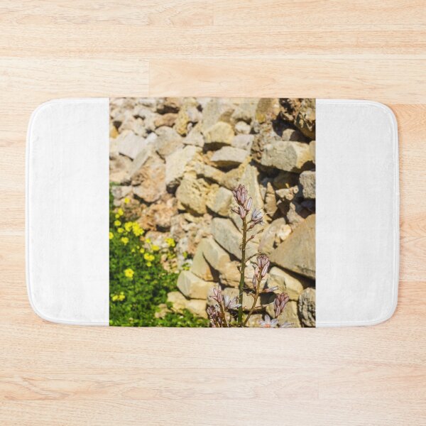 Item preview, Wildflower Blooming Against A Rustic Stone Wall With Yellow Clover And Blue Sky designed and sold by Nmallia.