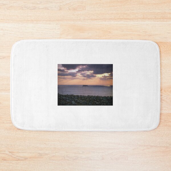 Item preview, Sunset Over Sea With Distant Islet and Foreground Stone Wall Under Dramatic Cloudy Sky designed and sold by Nmallia.
