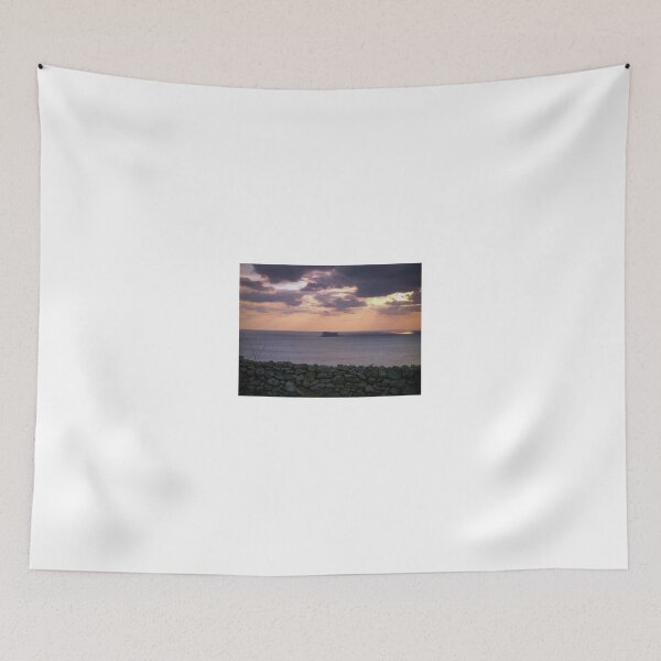 Item preview, Sunset Over Sea With Distant Islet and Foreground Stone Wall Under Dramatic Cloudy Sky designed and sold by Nmallia.