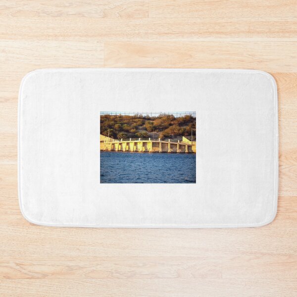 Item preview, Sunlit Stone Seawall With People Fishing Along Coastal Promenade At Golden Hour designed and sold by Nmallia.