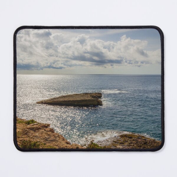 Item preview, Sunlit Rocky Coastline Overlooking Calm Ocean Waters Under Dramatic Cloudy Sky At Horizon designed and sold by Nmallia.