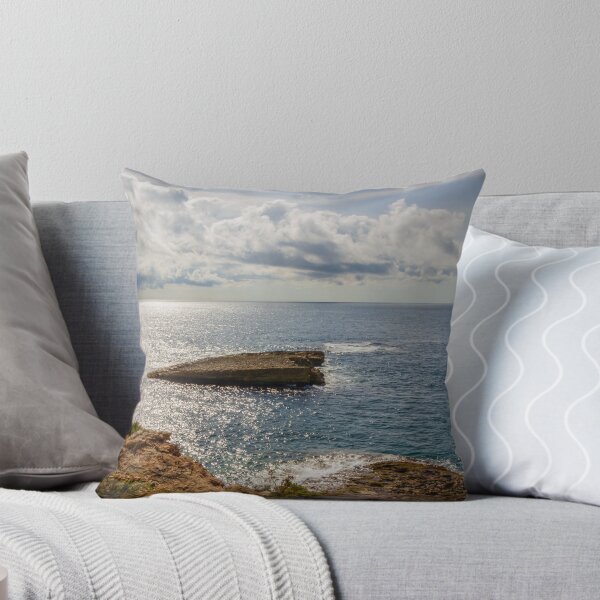 Item preview, Sunlit Rocky Coastline Overlooking Calm Ocean Waters Under Dramatic Cloudy Sky At Horizon designed and sold by Nmallia.