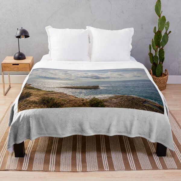 Item preview, Sunlit Rocky Coastline Overlooking Calm Ocean Waters Under Dramatic Cloudy Sky At Horizon designed and sold by Nmallia.