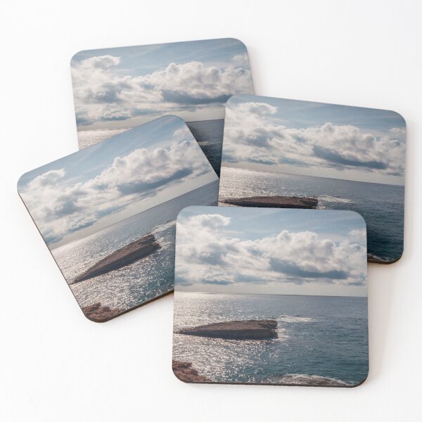Item preview, Sunlit Rocky Coastline Overlooking Calm Ocean Waters Under Dramatic Cloudy Sky At Horizon designed and sold by Nmallia.