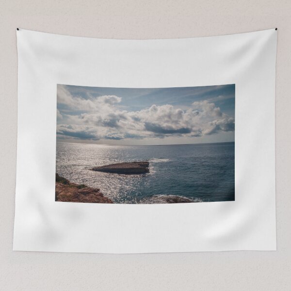 Item preview, Sunlit Rocky Coastline Overlooking Calm Ocean Waters Under Dramatic Cloudy Sky At Horizon designed and sold by Nmallia.