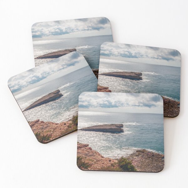 Item preview, Sunlit Rocky Coastline and Small Island Under Cloudy Sky With Calm Blue Sea and Sparkling Horizon designed and sold by Nmallia.