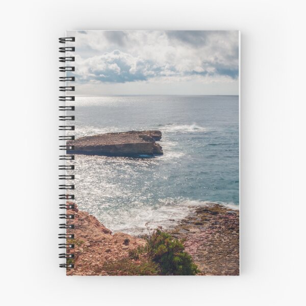 Item preview, Sunlit Rocky Coastline and Small Island Under Cloudy Sky With Calm Blue Sea and Sparkling Horizon designed and sold by Nmallia.